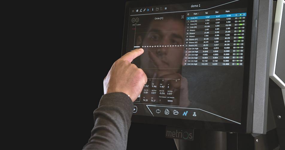 Mano di un operatore mentre mostra il funzionamento del display di una macchina Metrios